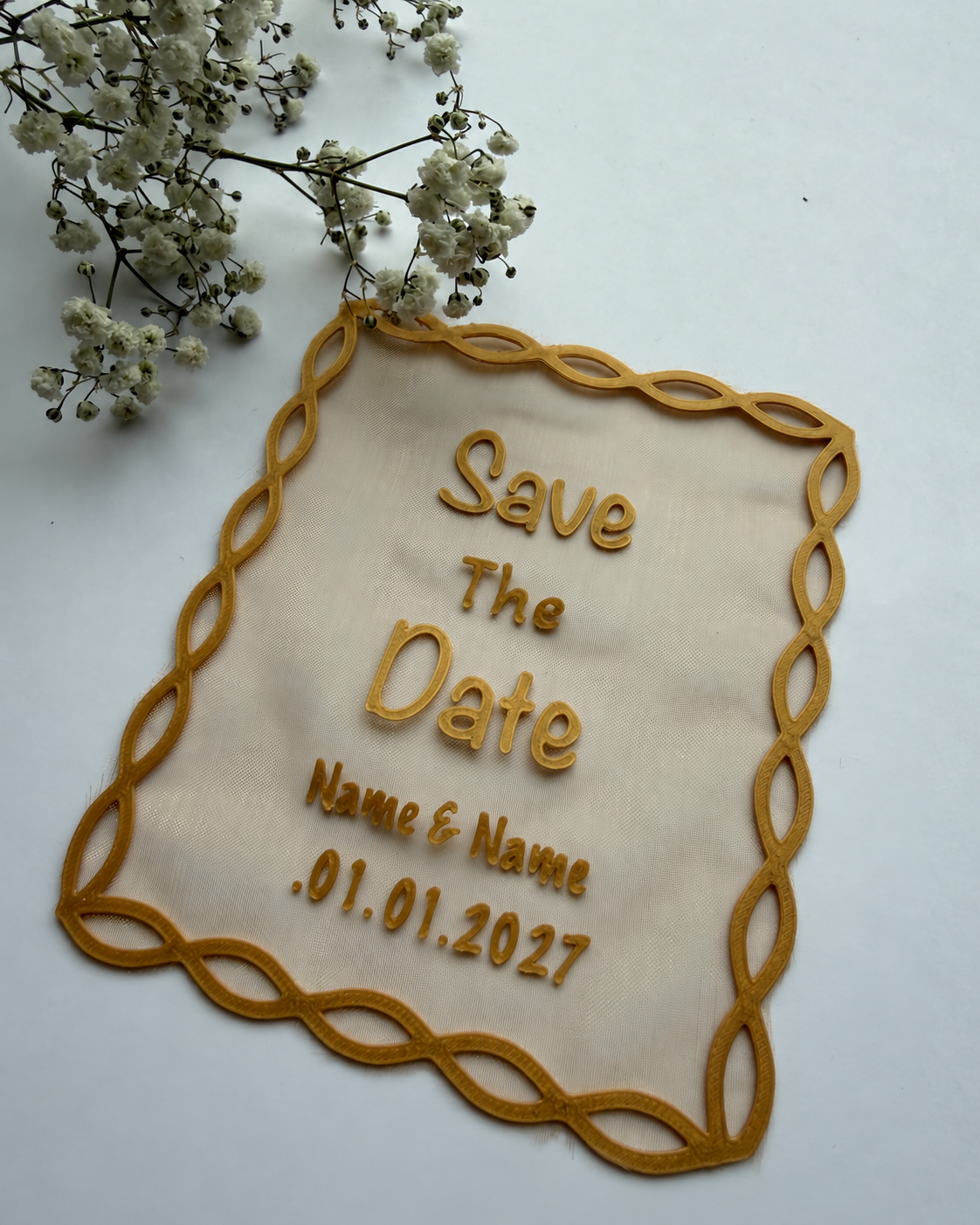 Romanttinen Save the Date -hääkortti, jossa kultaiset kohokirjaimet ja koristeellinen punosreunus.