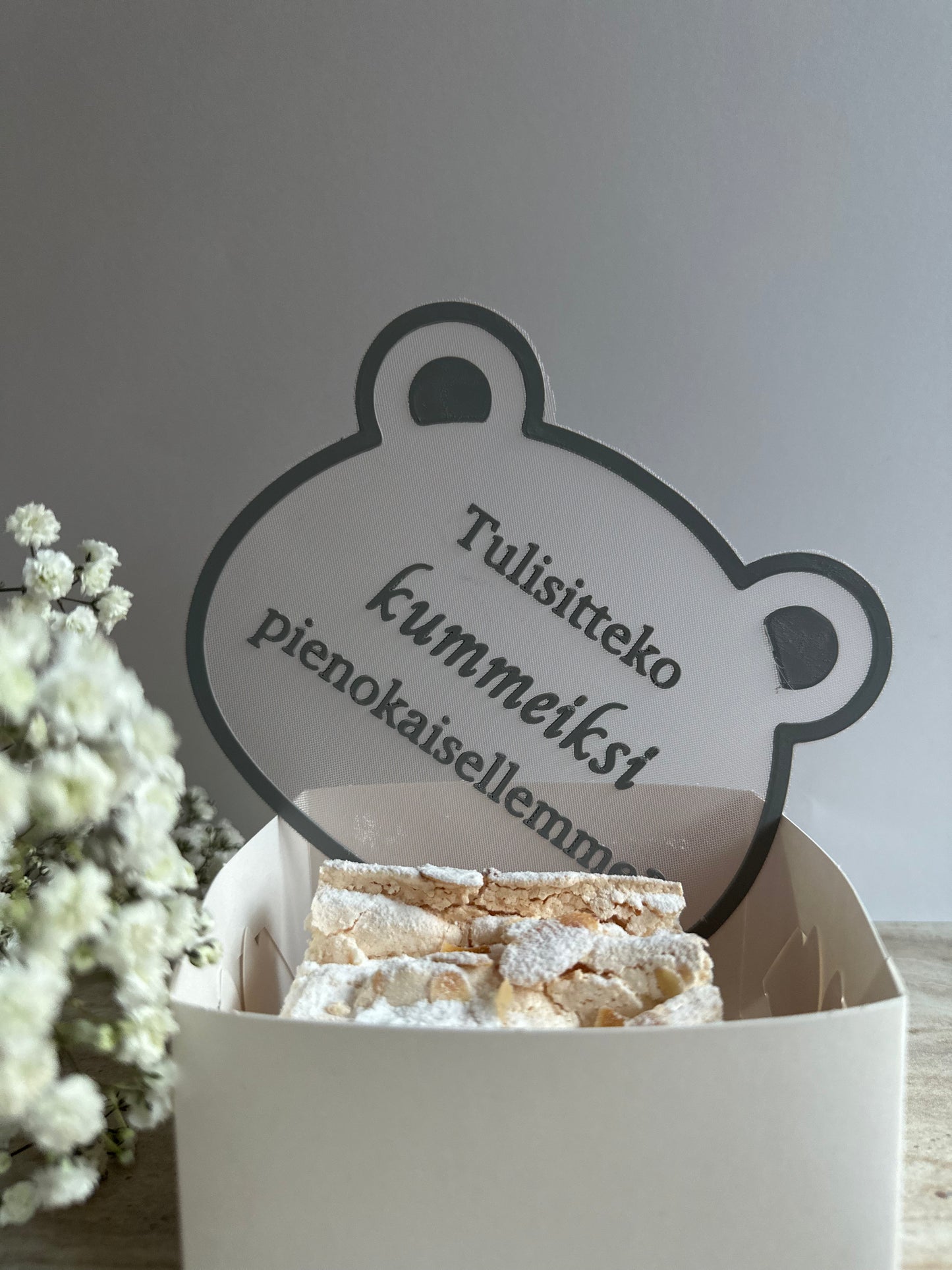 Söpö nallen muotoinen kummikutsu muistoksi tärkeästä hetkestä.